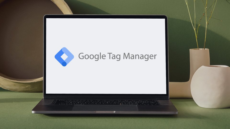 Laptop sobre la una mesa verde, con la pantalla encendida mostrando el logo de Google Tag Manager