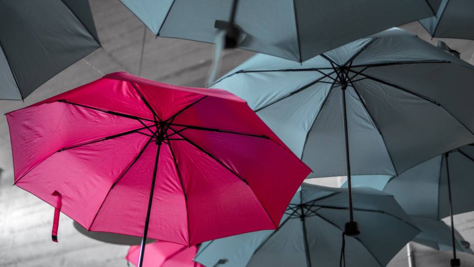 Paraguas rojo sobre fondo de paraguas grises