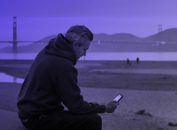 Hombre sentado buscando información en su telefono